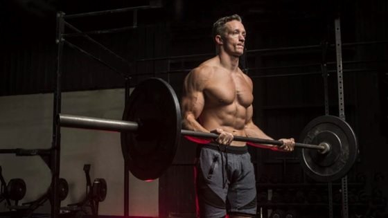 man curling heavy barbell stock image