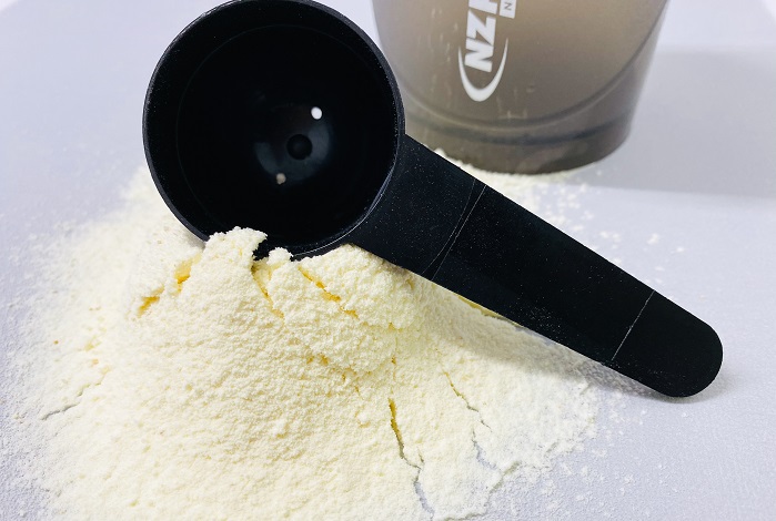 egg white protein powder on benchtop with black scoop