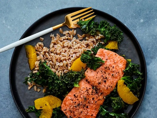 salmon and vegetable meal on a plate stock image