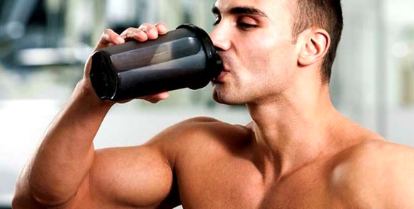 man drinking from a protein shaker stock image
