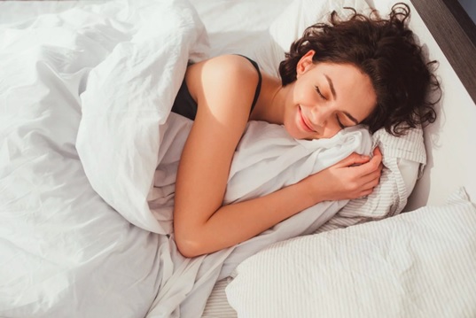 woman in bed enjoying sleep stock image