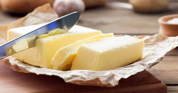 butter block being sliced by knife stock image