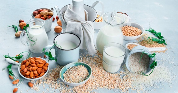 plant milks and almonds spread on white table stock image