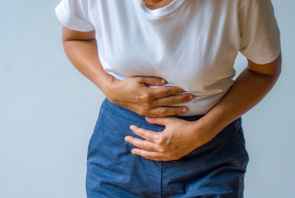 woman clutching stomach bent over stock image