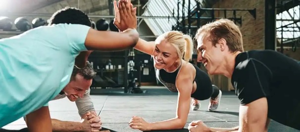 group of people exercising on gym floor mat high fiving stock image