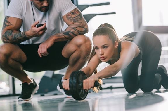 man training woman at gym holding watch stock image