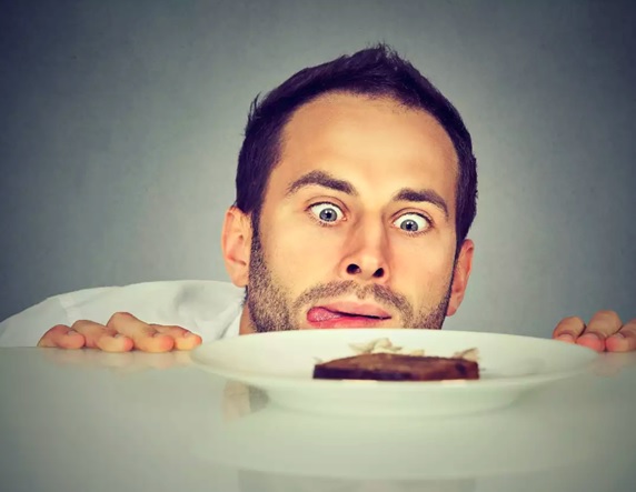 man looking over at a plate of food stock image
