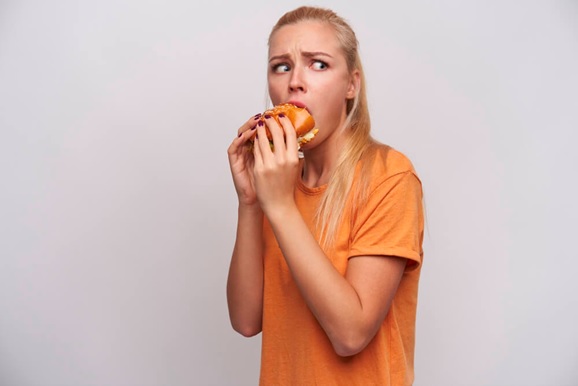 woman snacking on a burger stock image