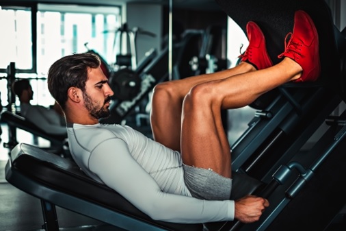 man on leg press machine stock image