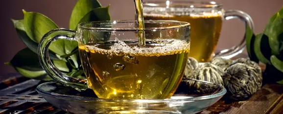 cup of green tea being poured stock image
