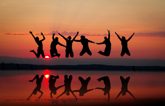 group jumping at sunset stock image