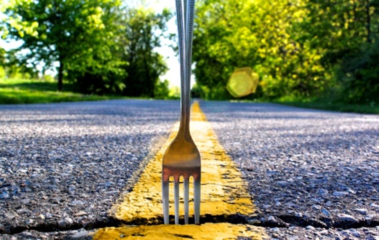 a utensil fork poked into a crack on the road stock image