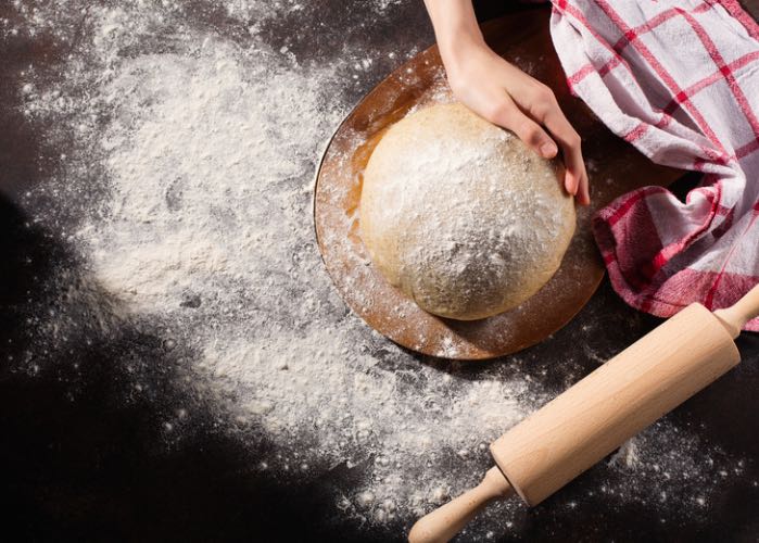 loaf of bread on a table with rolling pin