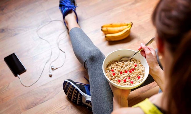 fit woman eating from a bowl stock image