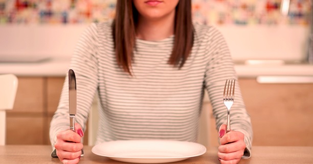 woman holding knife and fork with empty plate stock image