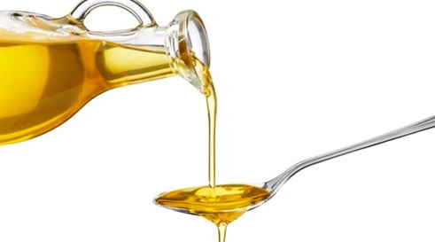 oil being poured onto a spoon stock image