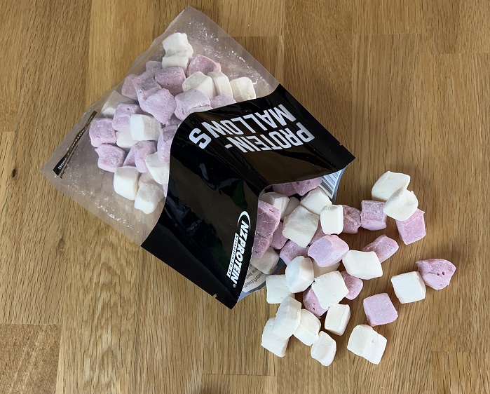 protein marshmallows spilling out of bag on brown table