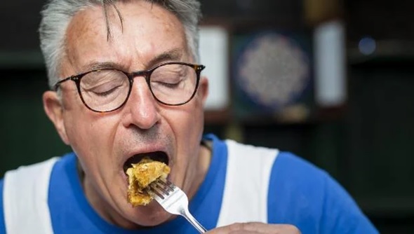 man eating food with a fork stock image