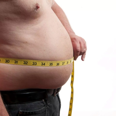 man with tape measure around large belly stock image
