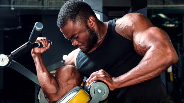 man on bicep curl machine stock image