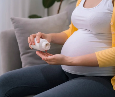 pregnant woman with capsules stock image