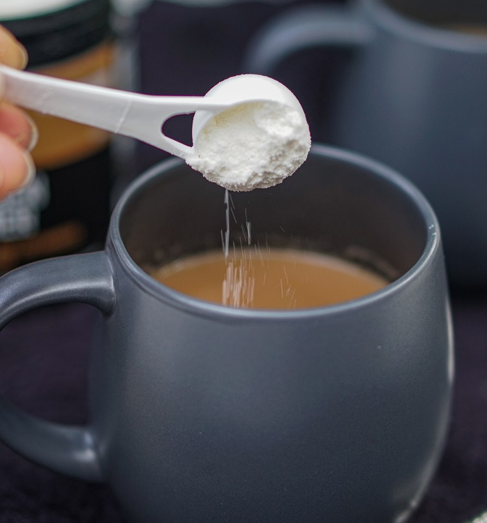 scoop of collagen creamer tipped into hot mug