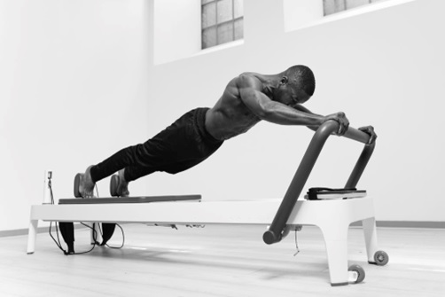 man using a machine to stretch and strenghen core black and white stock image