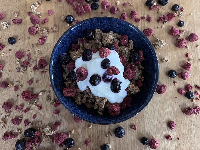 protein granola in blue bowl with yoghurt and berries