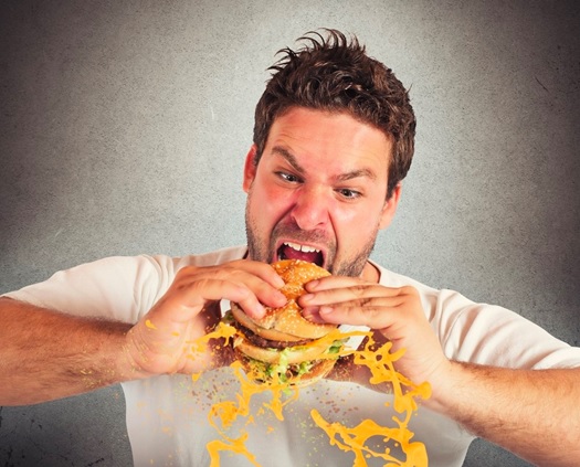 main eating a hamburger aggressively stock image