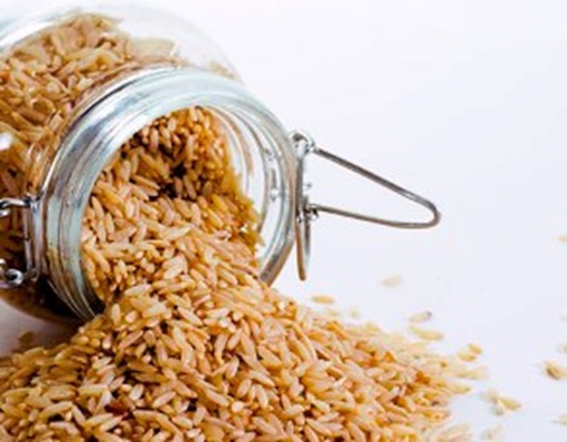 rice spilling out of a glass jar stock image