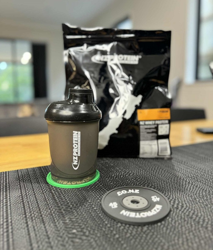 nzprotein drink coasters on a table with a shaker and bag of protein
