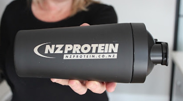 woman holding NZProtein stainless steel shaker bottle