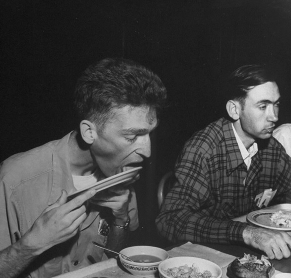 thin men eating food at a table black and white