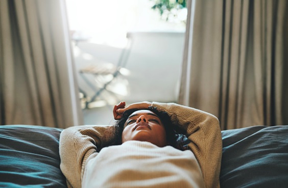 woman resting on a bed stock image