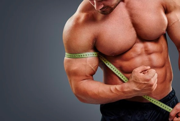 strong man with tape measure around bicep stock image