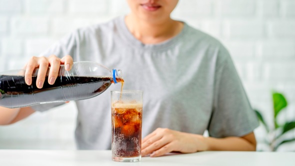 woman pouring a soft drink into a glass stock image