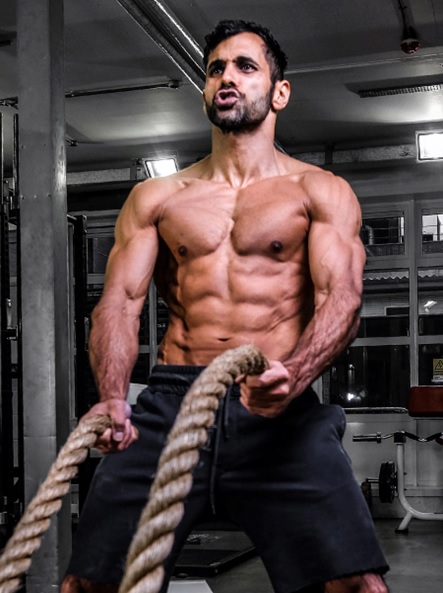 man at gym with ropes and no shirt stock image