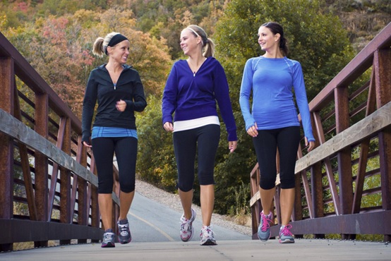 women walking together over bridge stock image