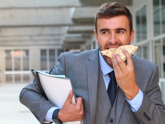 man in suit eating and working stock image