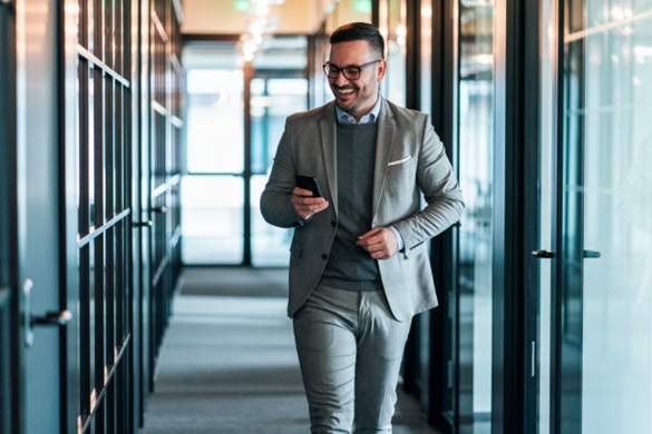 man walking and looking at phone stock image