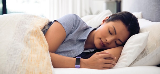 woman sleeping in bed with fitness watch on wrist stock image