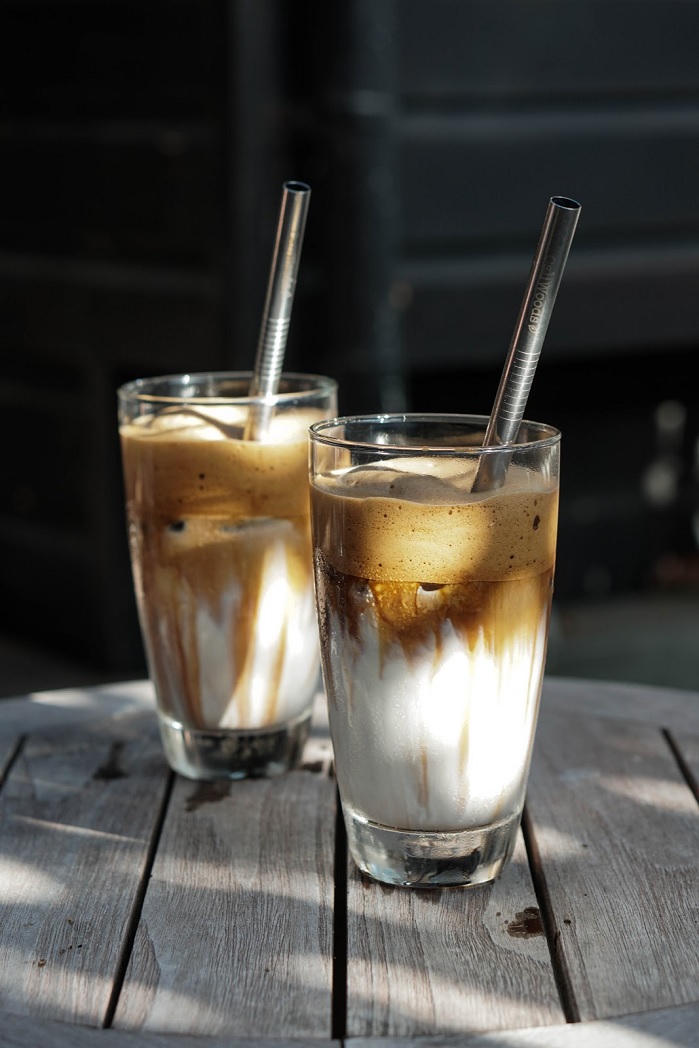 whipped collagen coffee in glass with metal straw