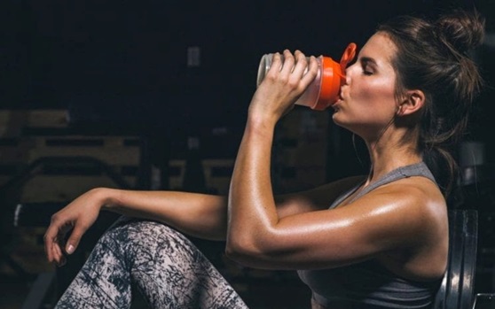 woman drinking a protein shake seated stock image