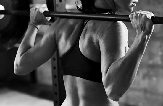 woman squatting barbell stock image