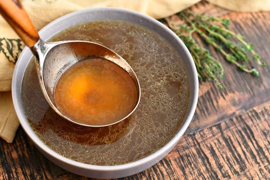 bowl of stock soup with serving spoon stock image