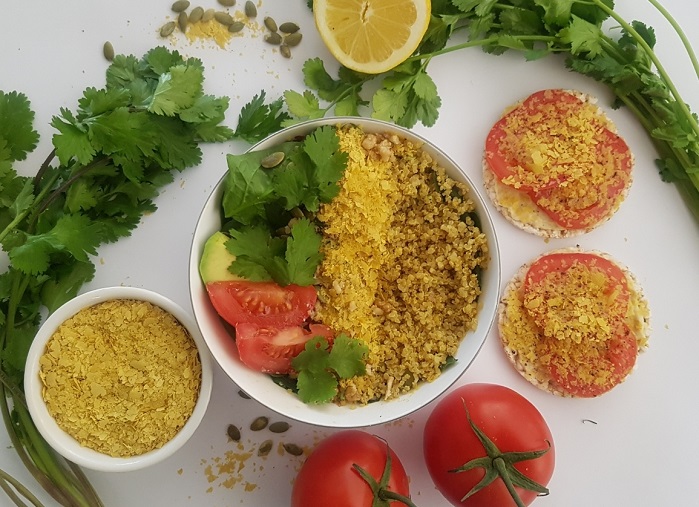 nutritional yeast flakes in a bowl and sprinkled over vegetables